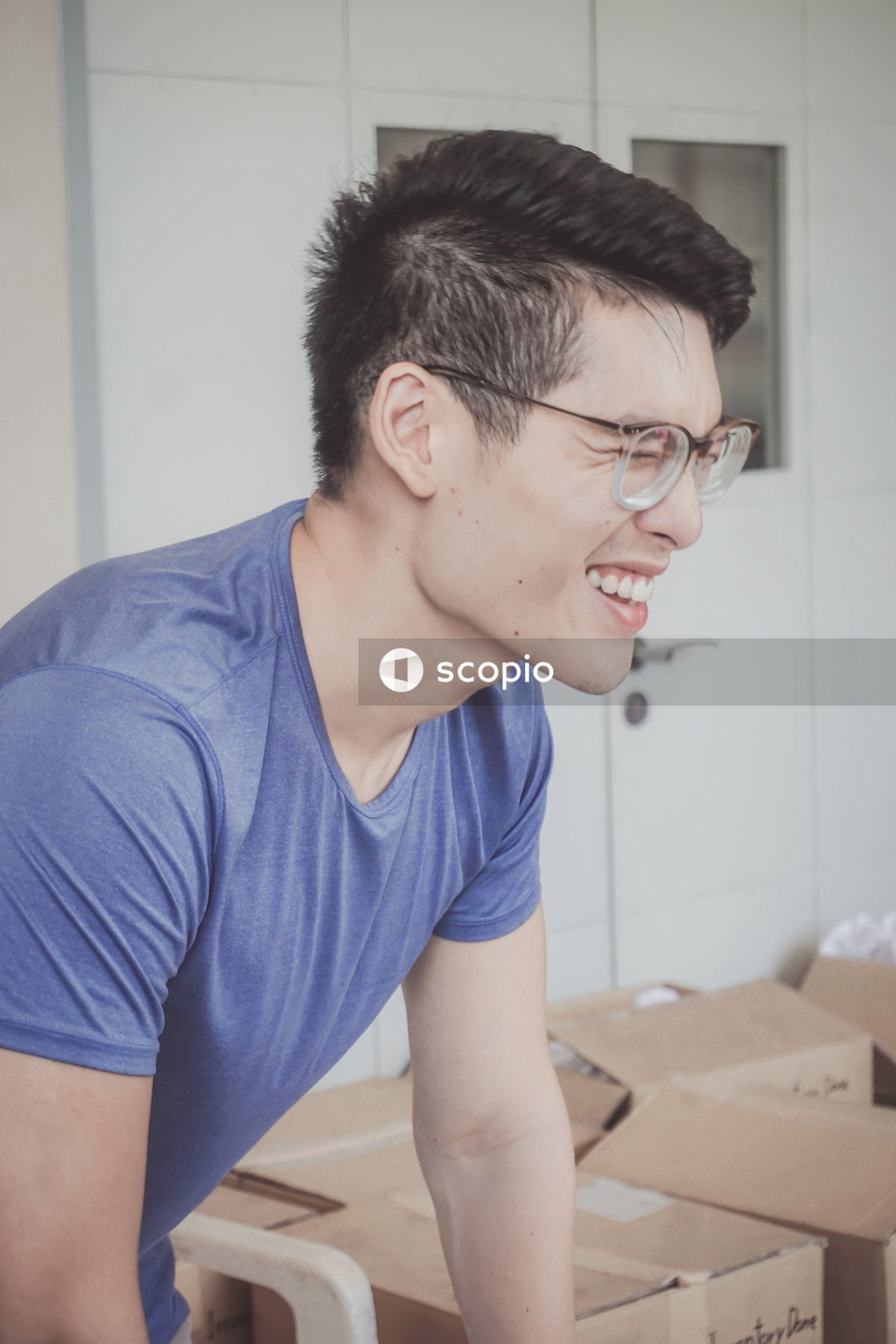 Side view of smiling man in blue shirt with eyeglasses