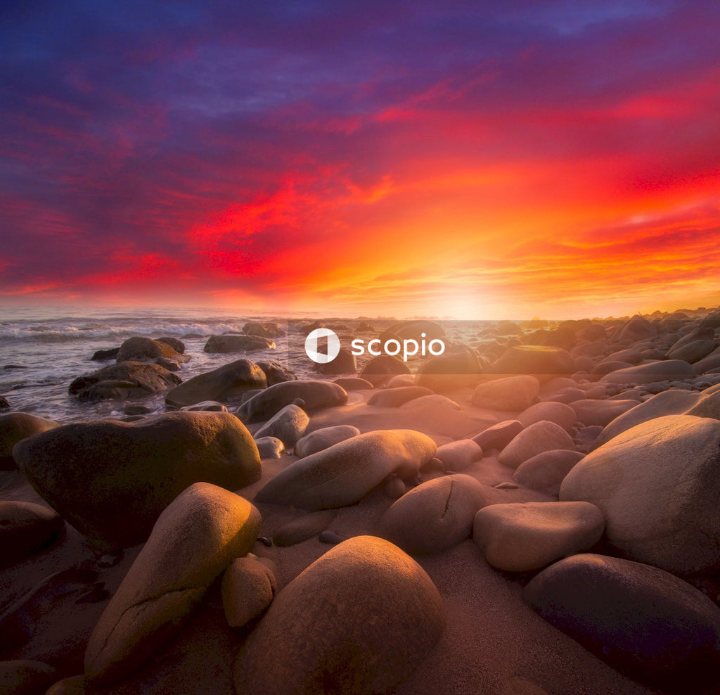 Brown rocks on sea shore during sunset