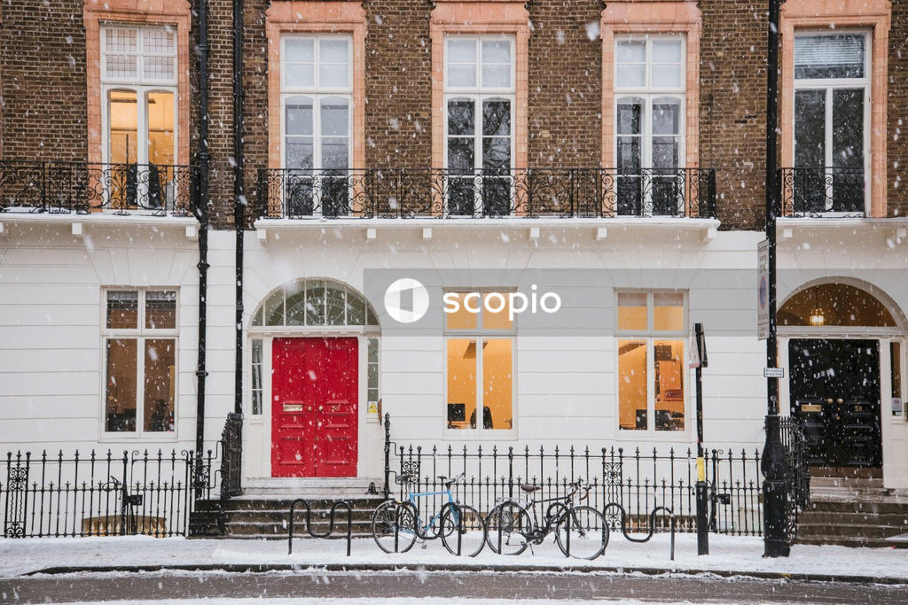 Snow raining over white and brown building