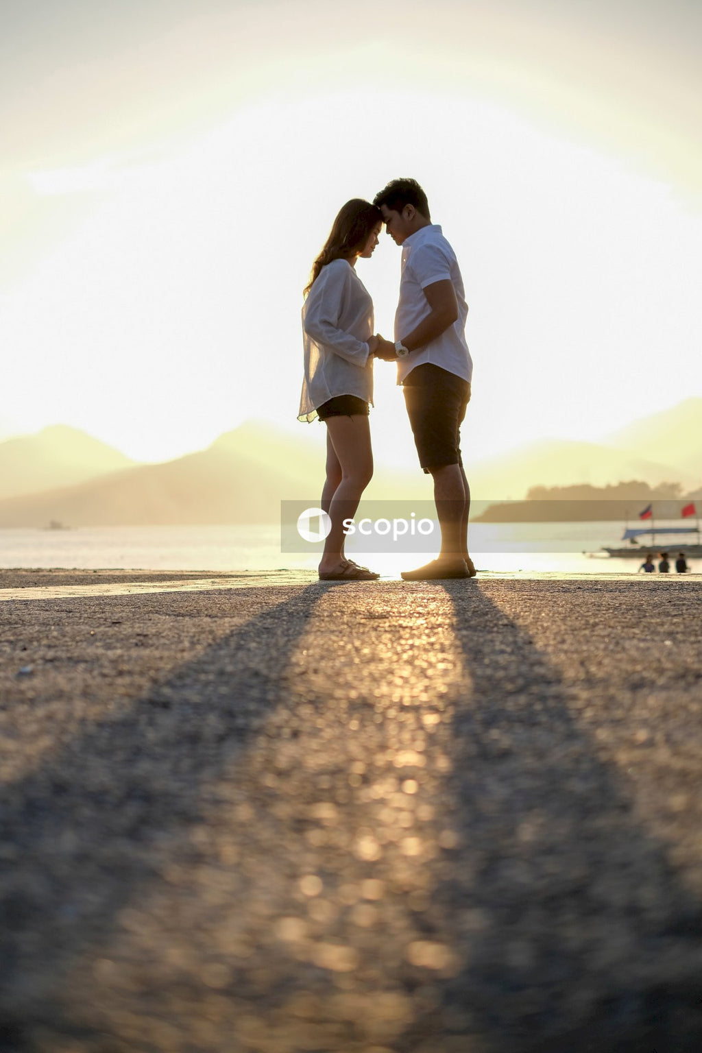 Man and woman leaning into each other near body of water