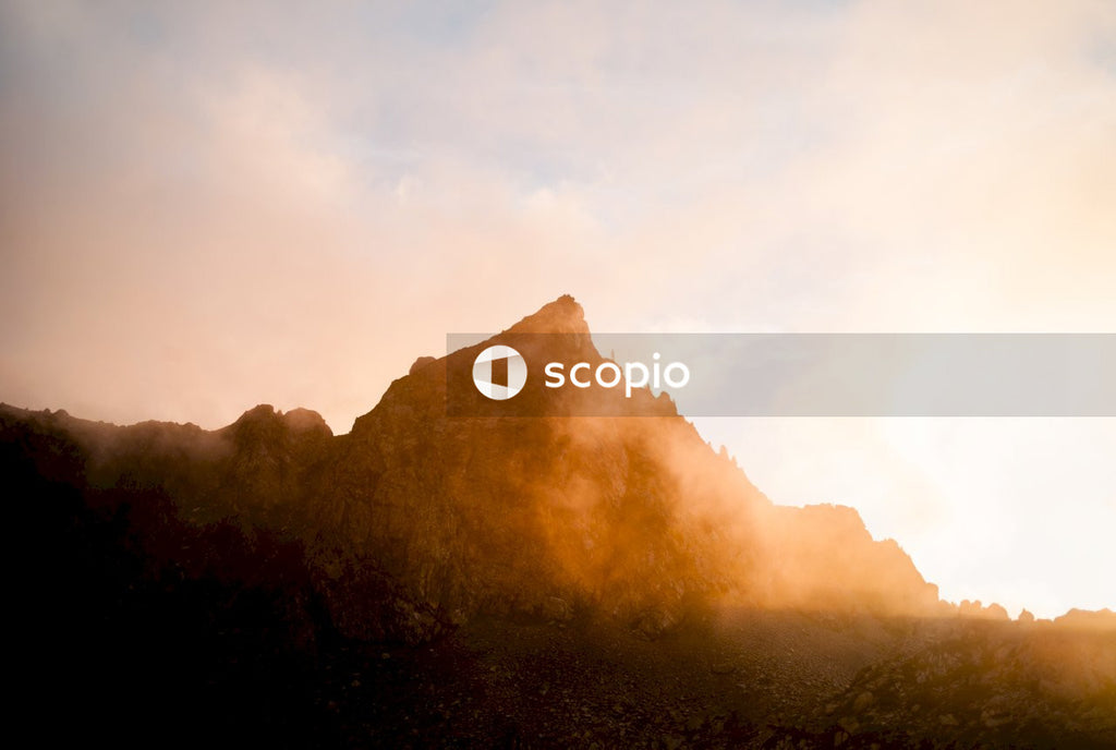 Brown mountain under white clouds during sunset