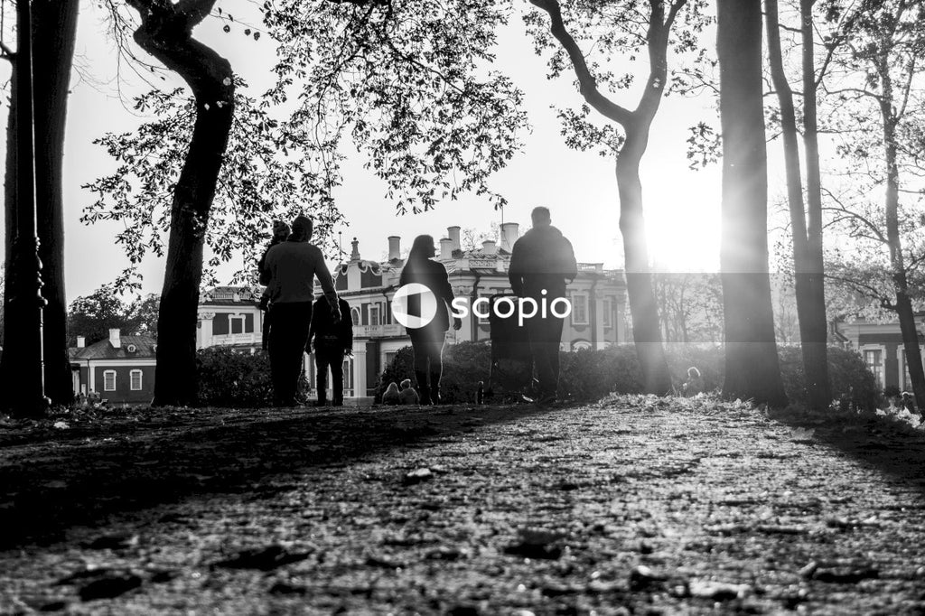 Grayscale photo of people standing near tree