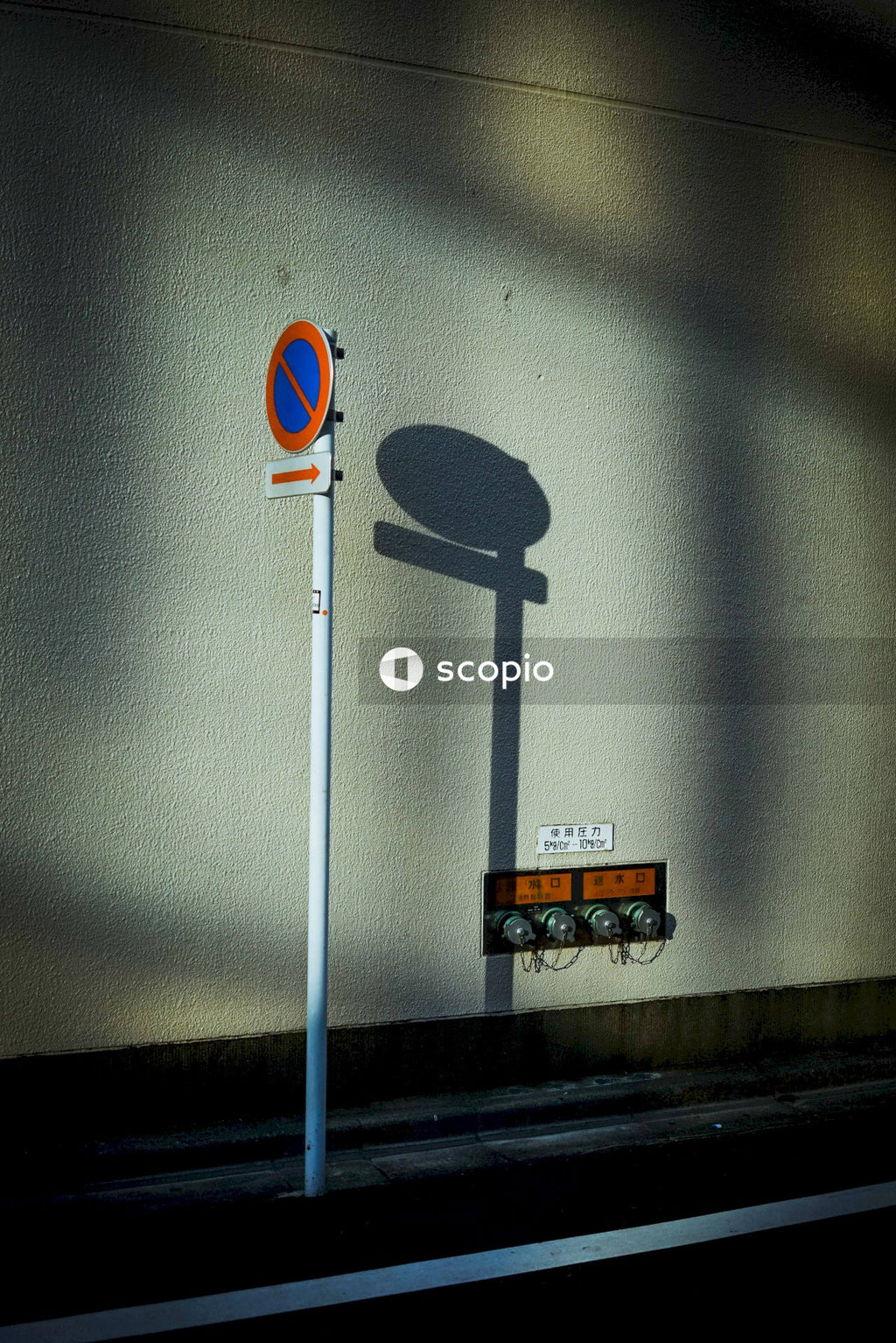 Street sign with shadow on wall
