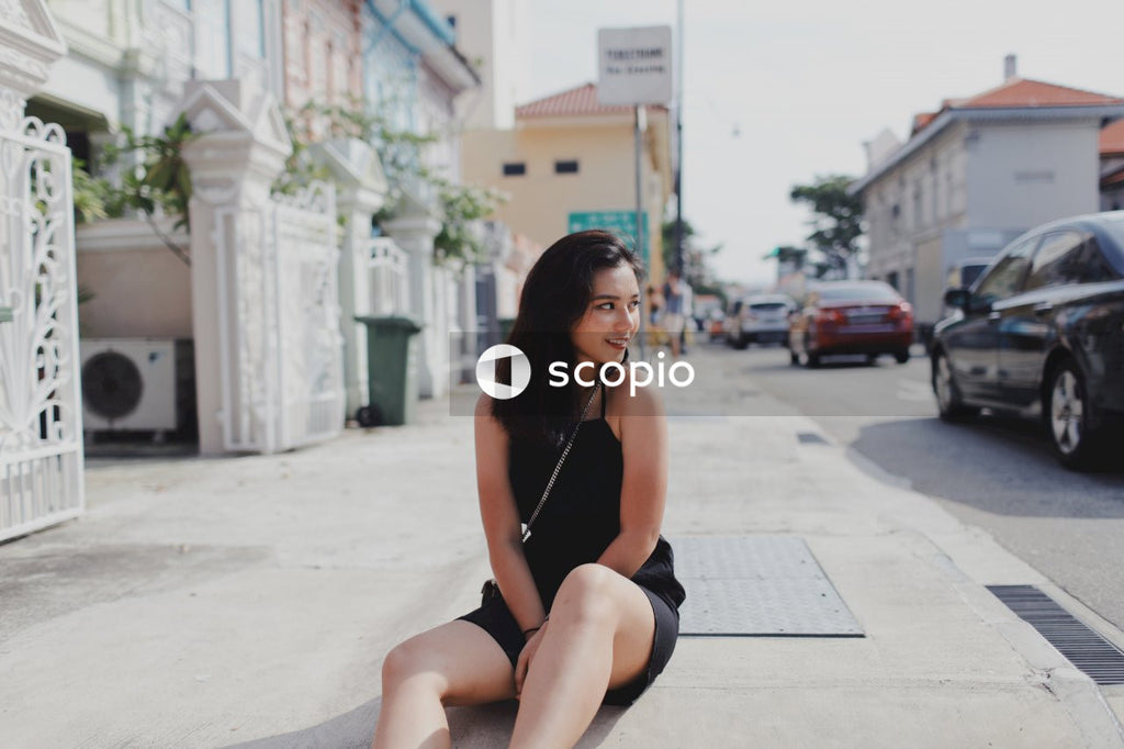 Woman on street posing near building