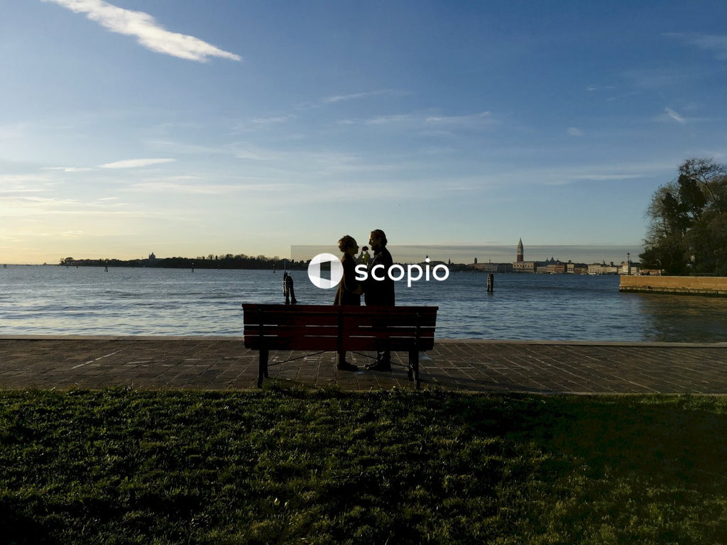 Couple sitting on bench near sea