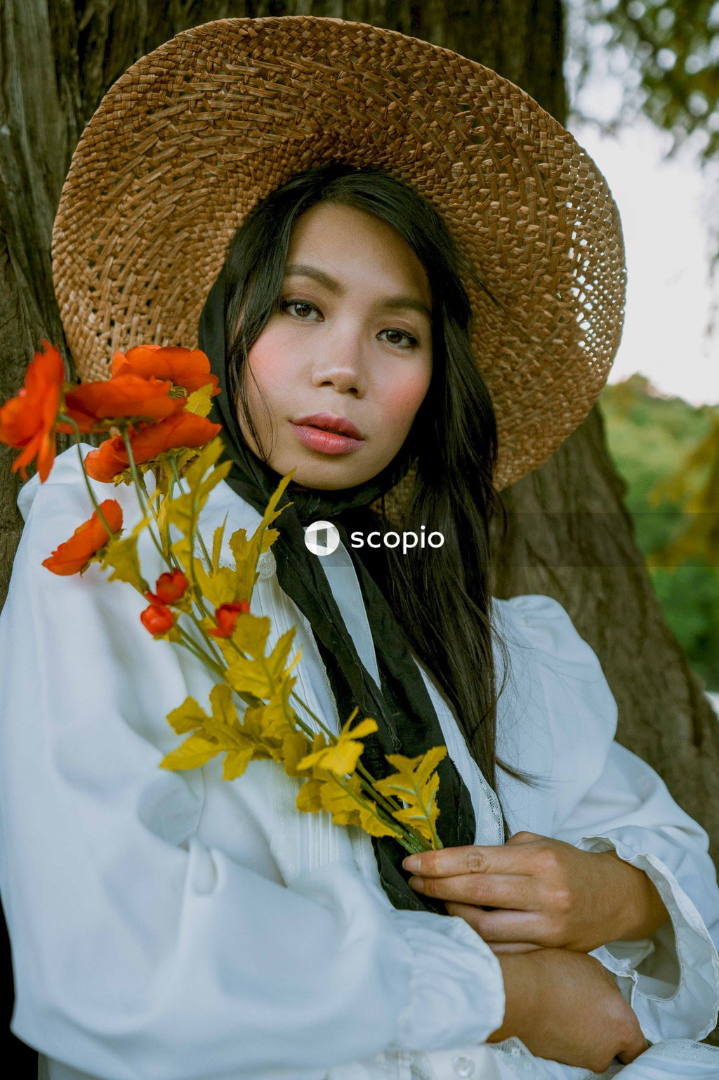 Woman in white long sleeve shirt wearing brown straw hat