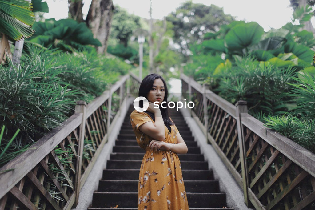 Asian woman in orange dress standing on stairs