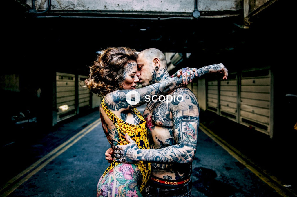 Woman in purple and yellow floral dress hugging man in black shirt