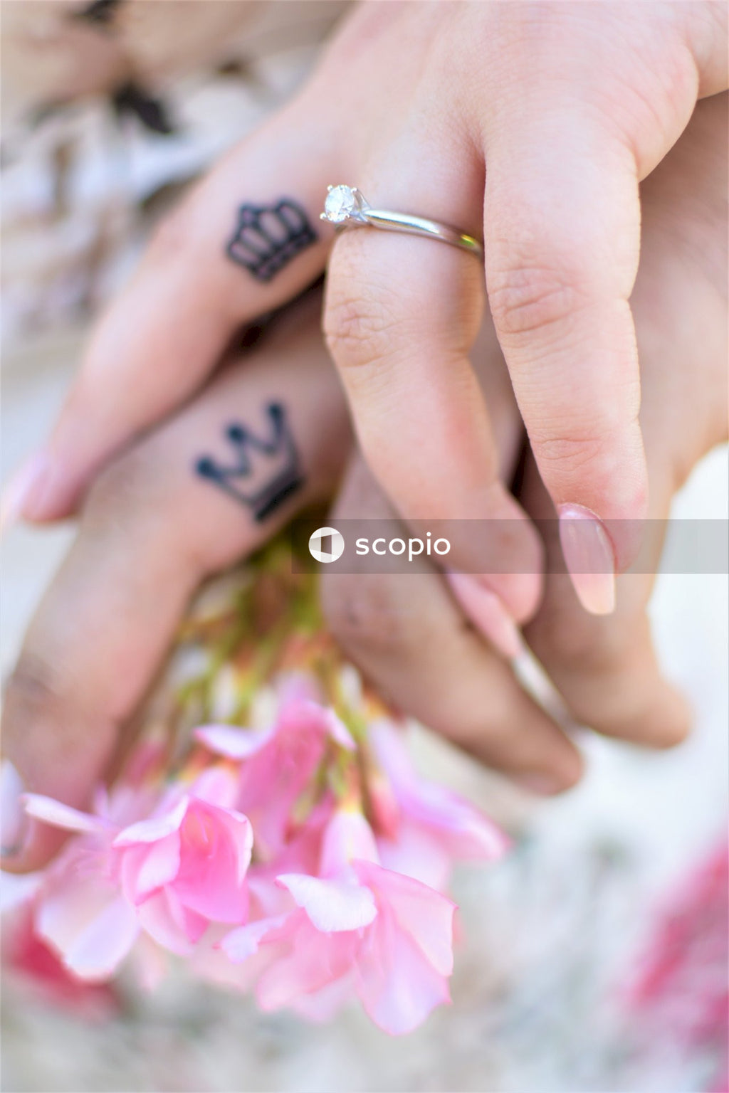 Cropped hands of man and woman with matching King and Queen tattoos