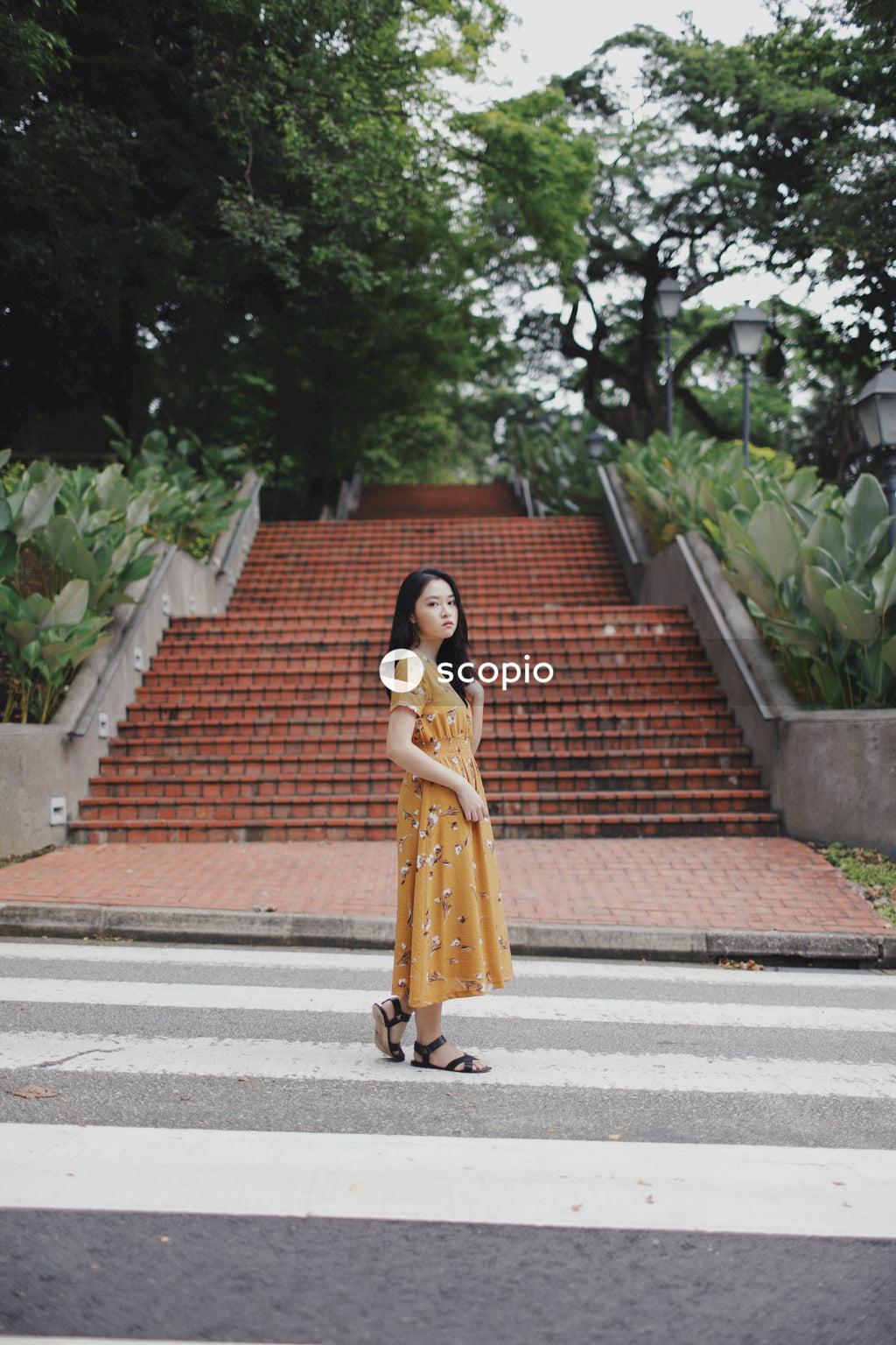 Woman in yellow dress standing in front of red stairs