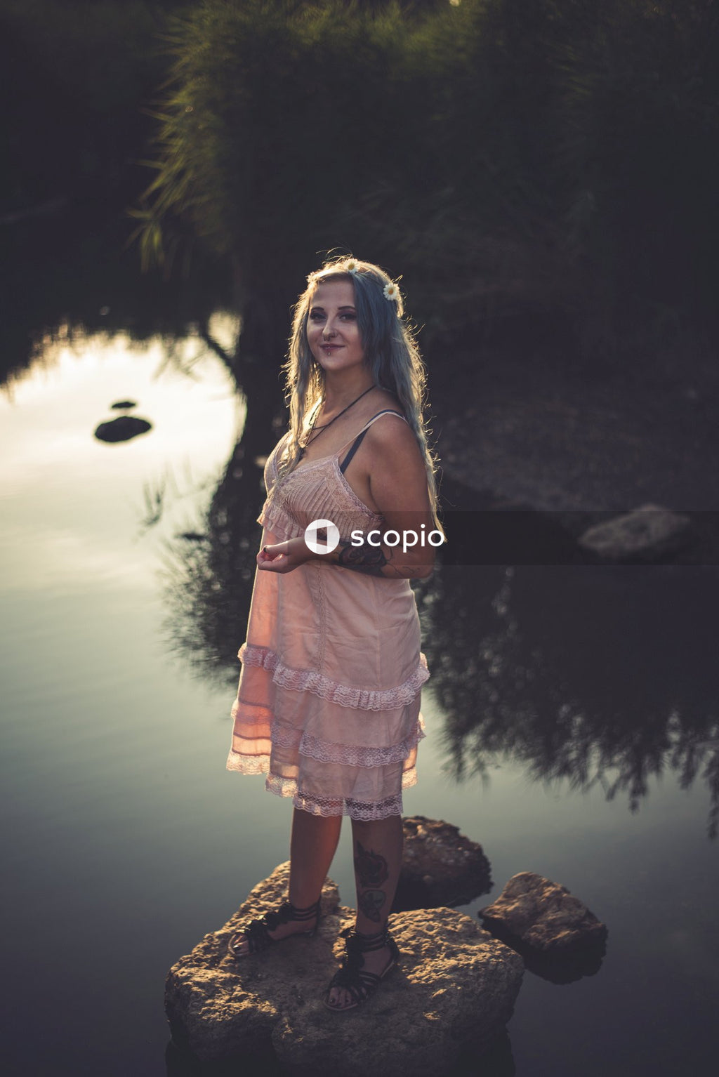 Woman in white and pink dress standing near body of water