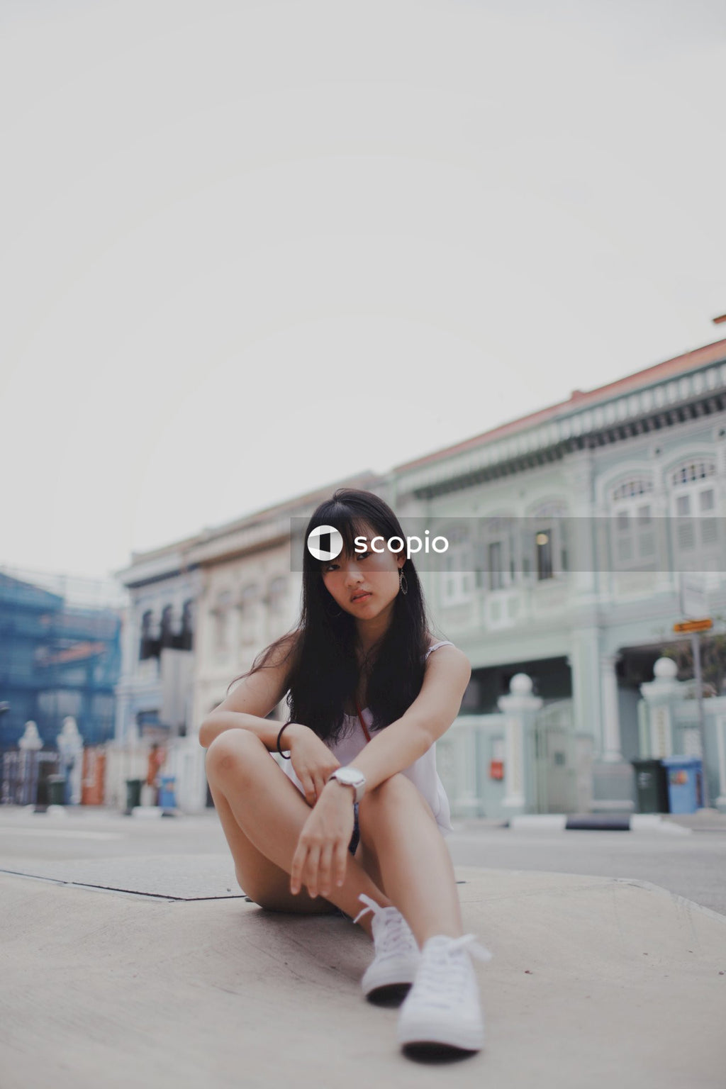 Girl posing on the floor in front of building
