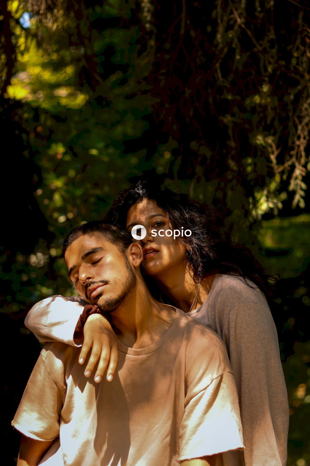 Woman in gray long sleeve shirt hugging man in white dress shirt