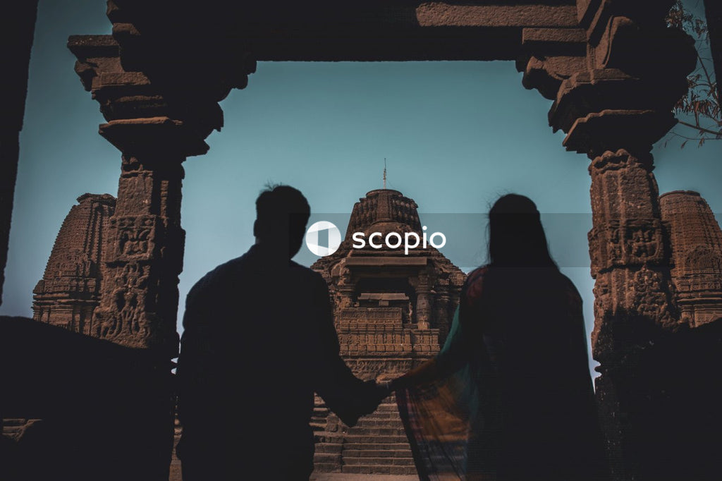 Couple holds hands near ancient temple