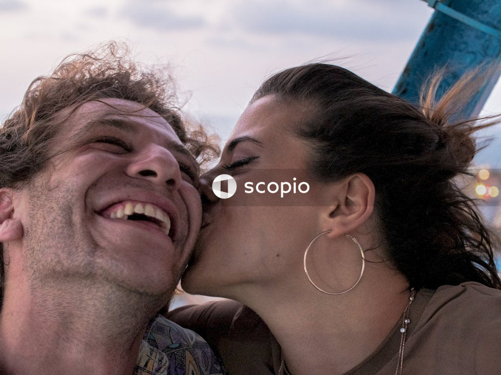 Woman kissing a man while he's laughing