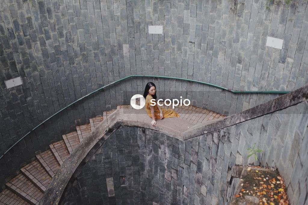 Woman in orange dress sitting on stairs