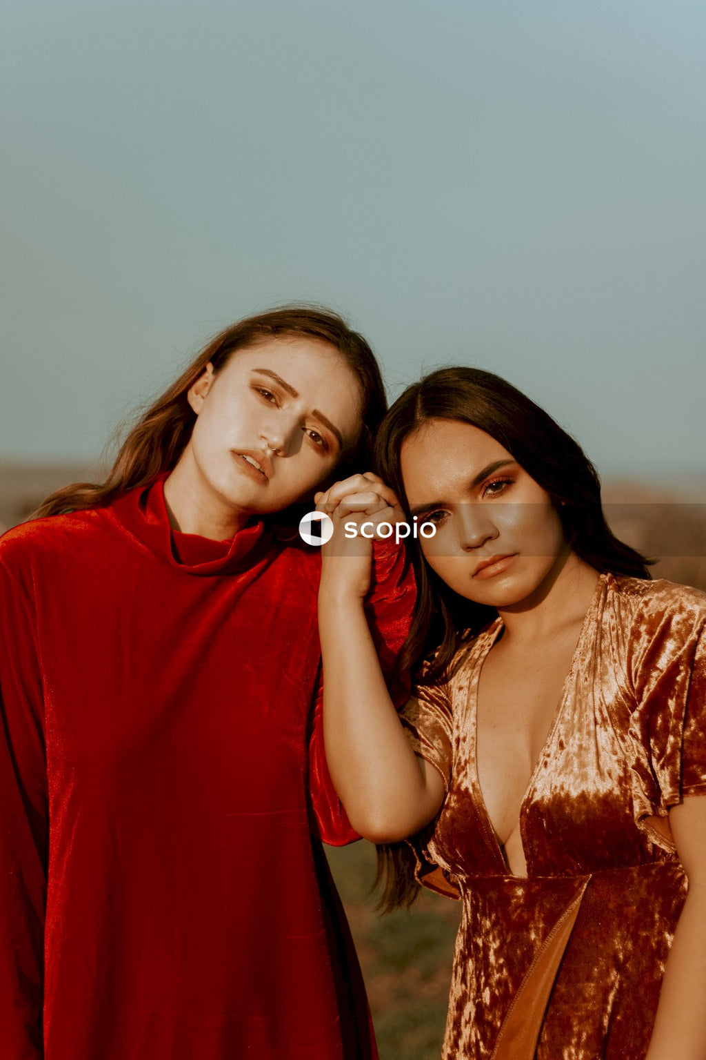 Two girls holding each others hands at sunset in nature