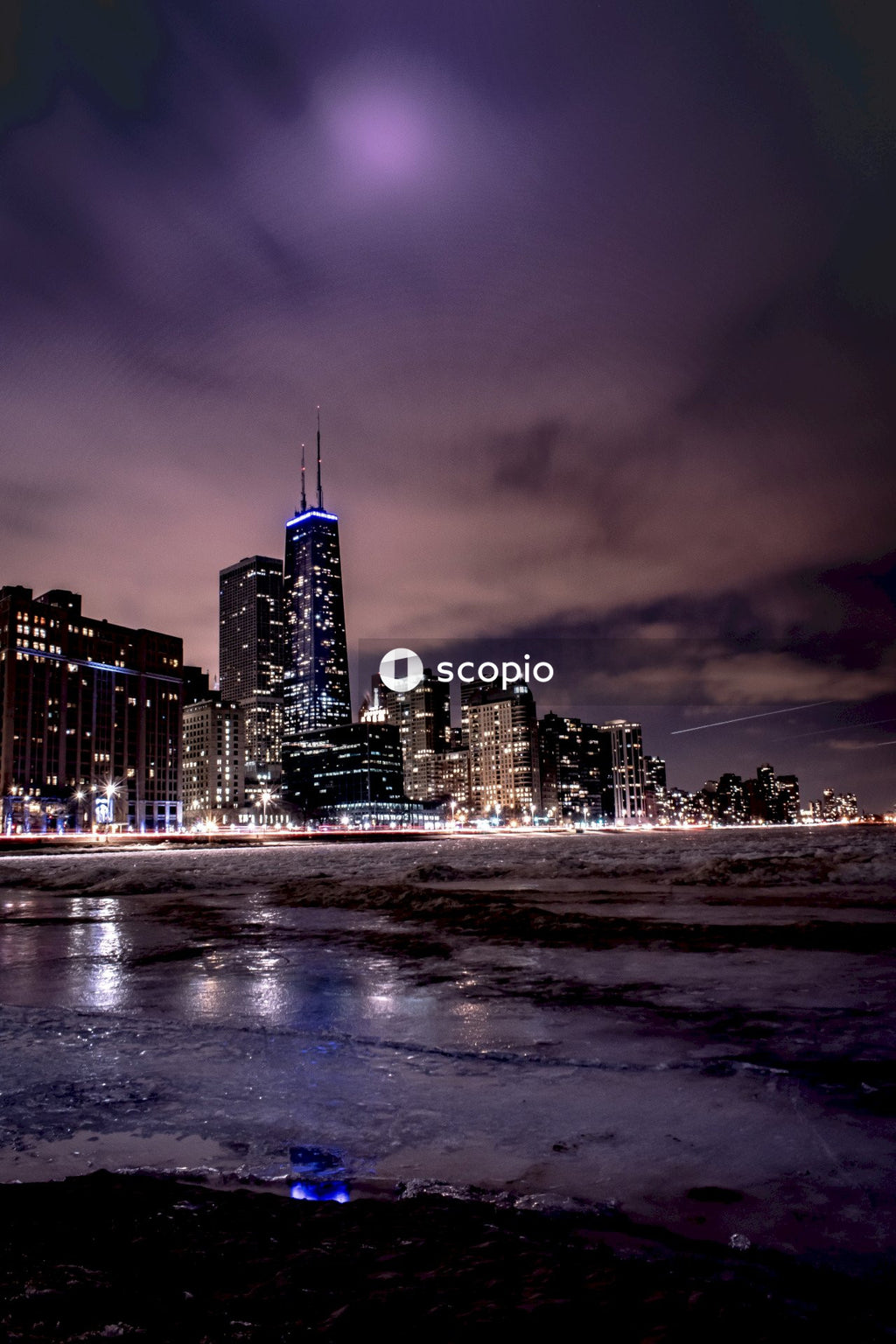 City skyline under gray clouds during night time