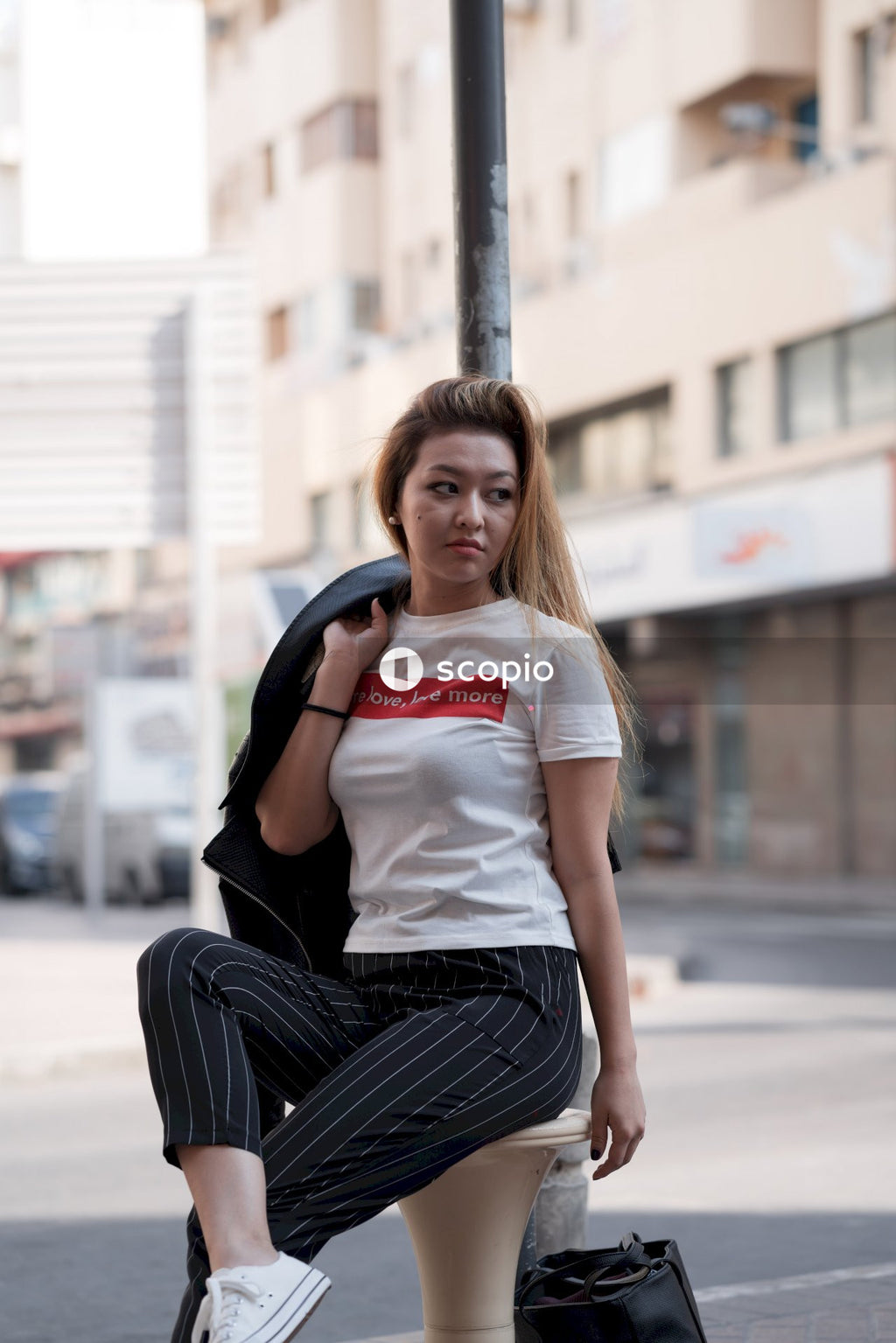 Woman in white crew neck t-shirt and black pants sitting on concrete bench