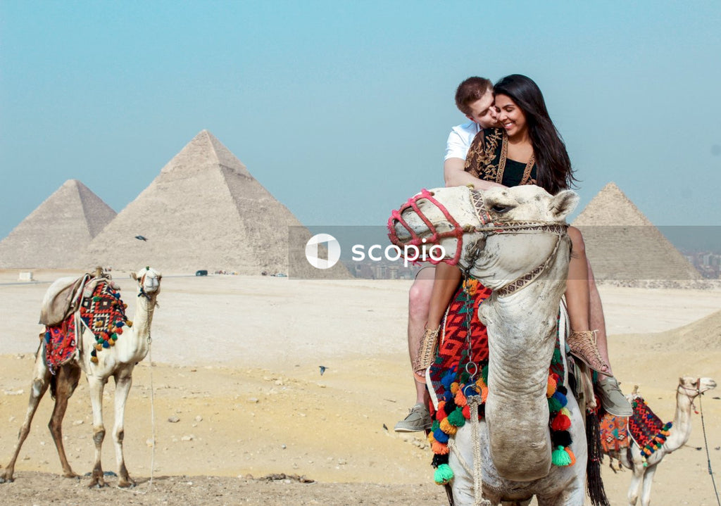Couple riding camel, egypt