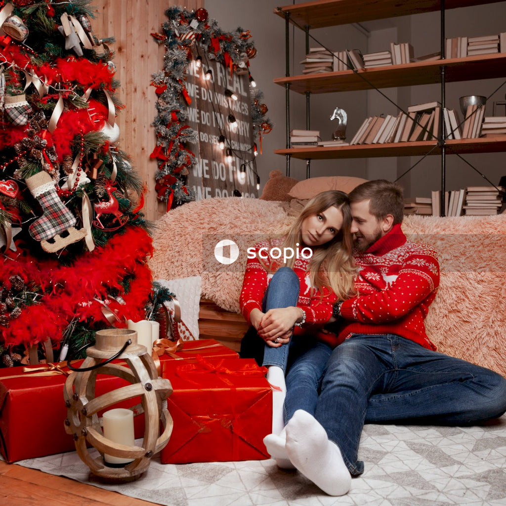 Couple sitting beside christmas tree