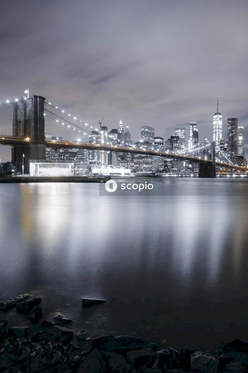 Bridge over water near city buildings during night time