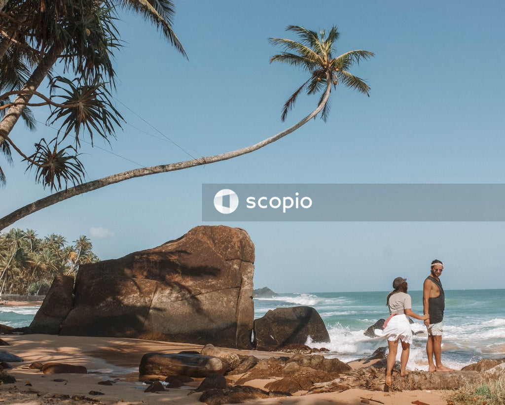 Couple standing on rock on seashore