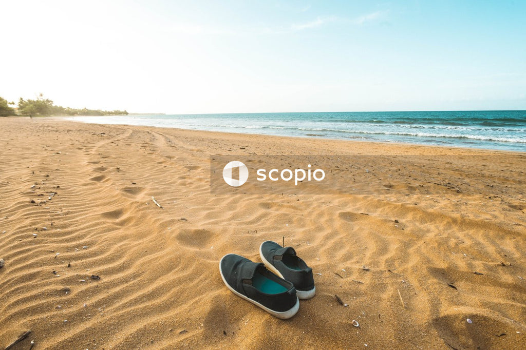 Black and white sun hat on brown sand near sea