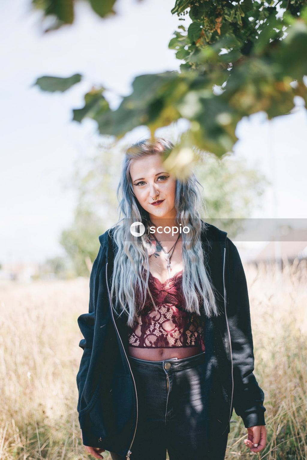 Woman in black blazer standing on brown grass field