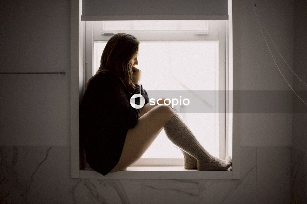 Woman in black long sleeve shirt sitting on window
