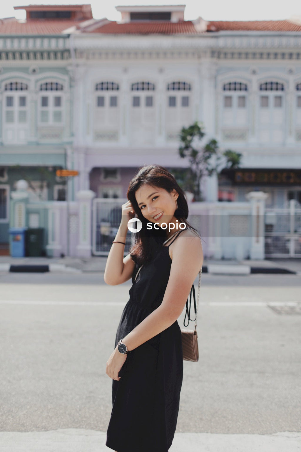 Woman on street posing near building