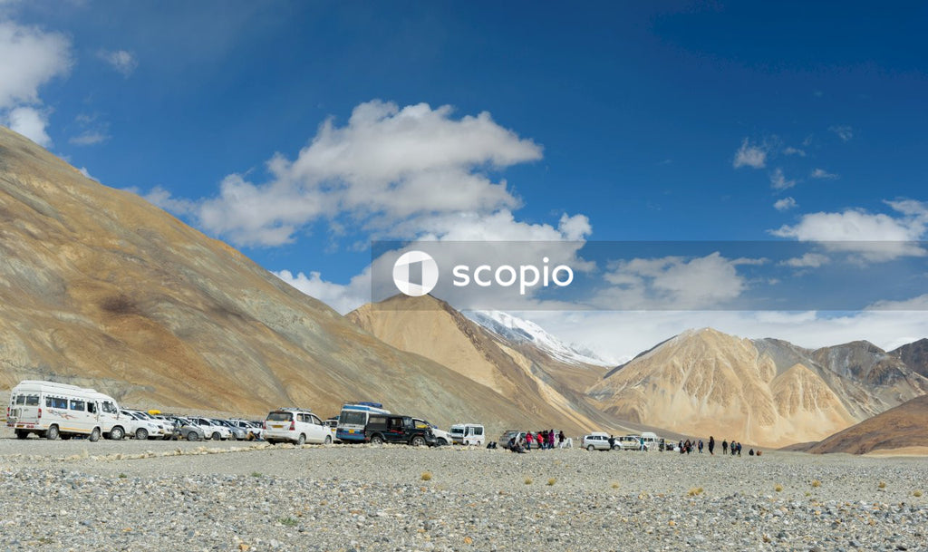 White and black cars on gray sand under blue sky