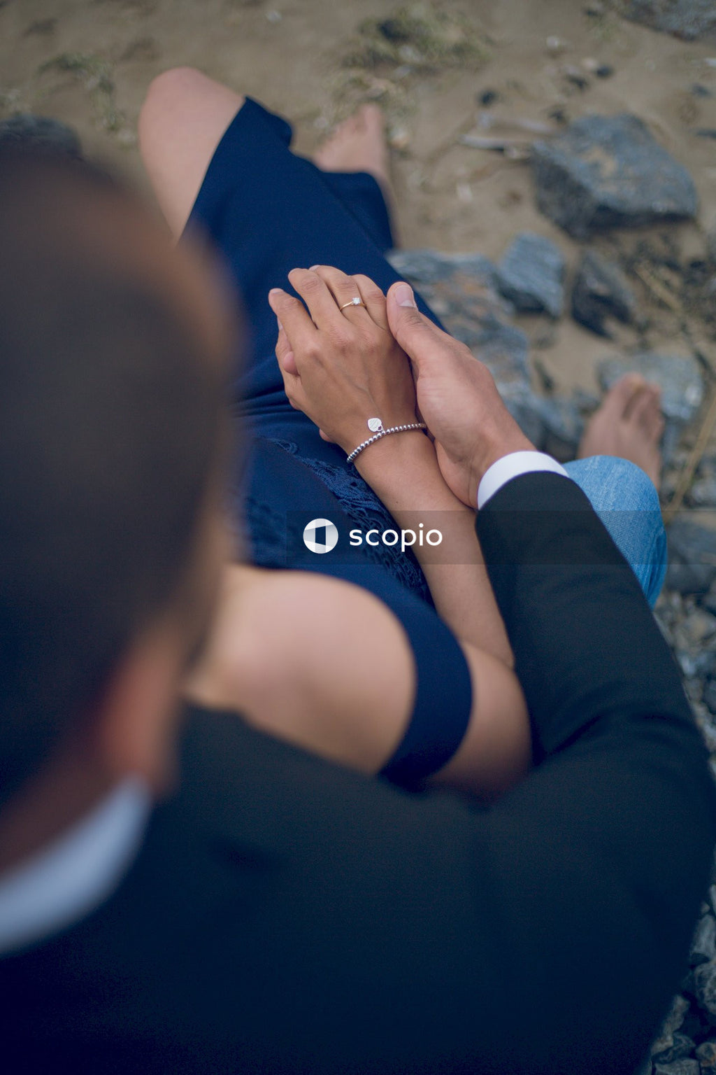 Couple sitting by the beach holding hands