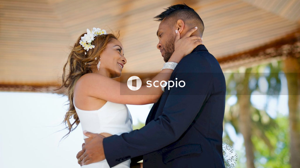 Man in black suit kissing woman in white dress