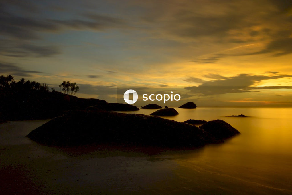 Silhouette of person standing on rock formation during sunset