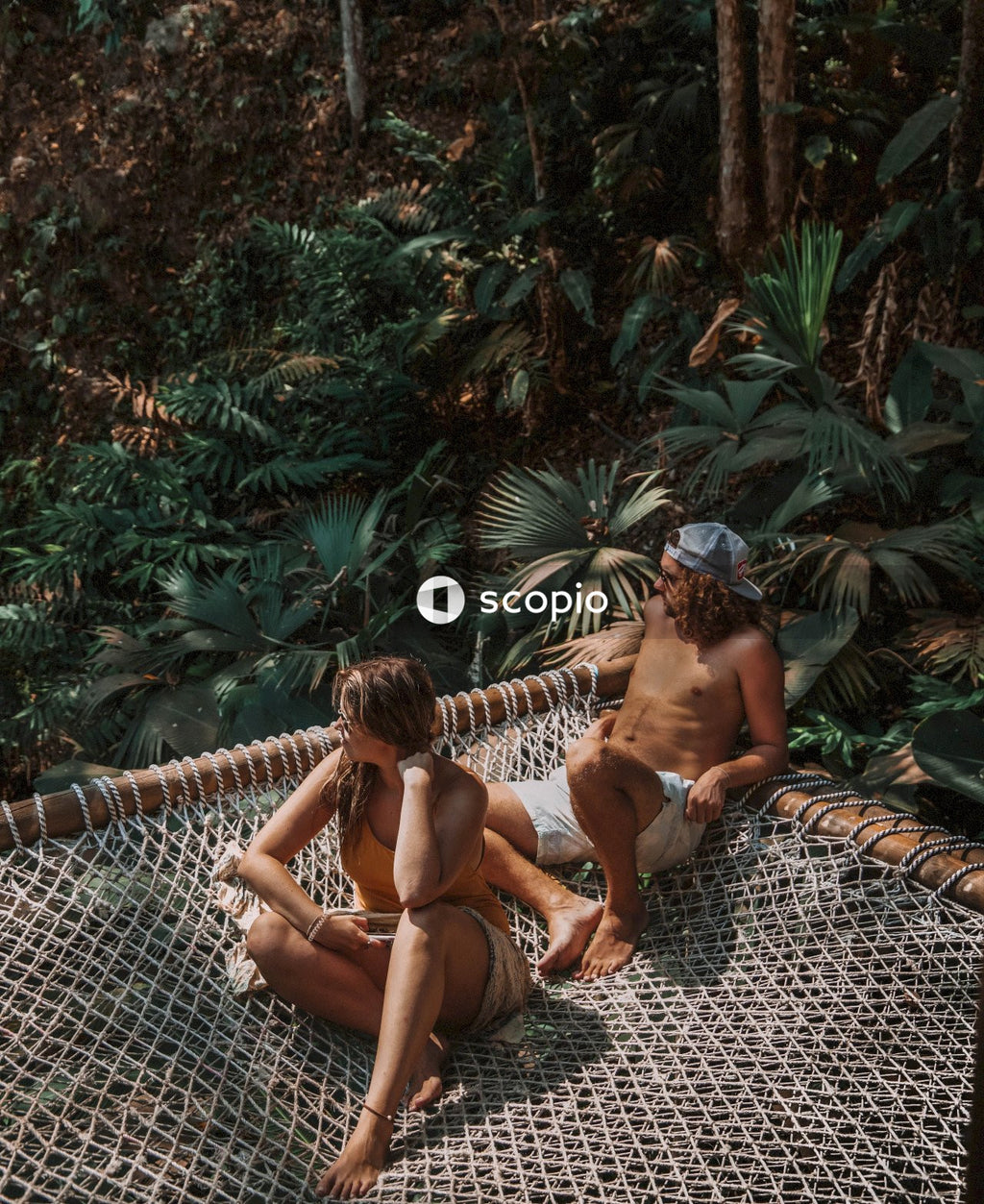 Man and Woman relaxing on canopy roof near trees