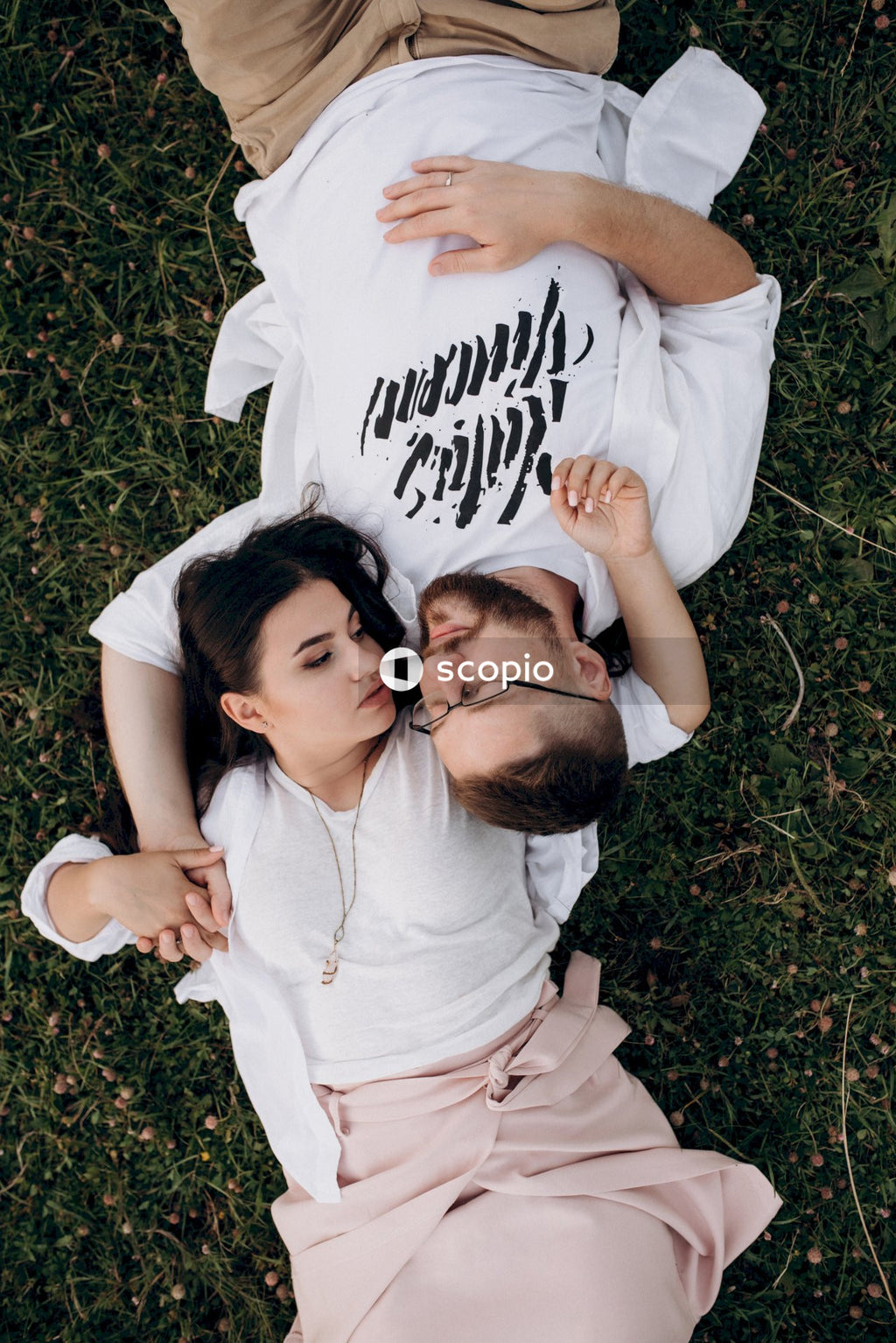 Man and woman lying on green grass
