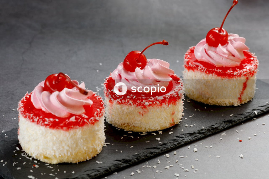 2 white and red cupcakes on black wooden table
