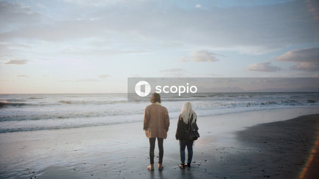 Man and woman standing on the beach during sunset