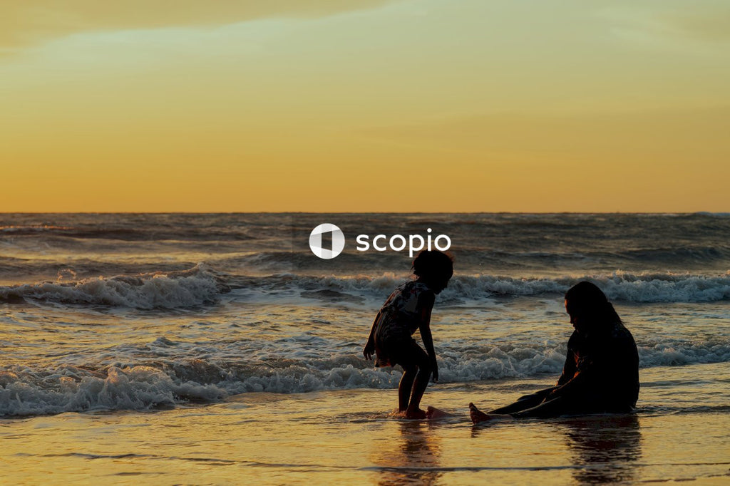 2 women walking on beach during sunset