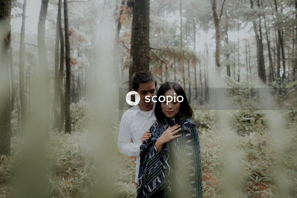 Man in white dress shirt hugging woman in blue and white dress