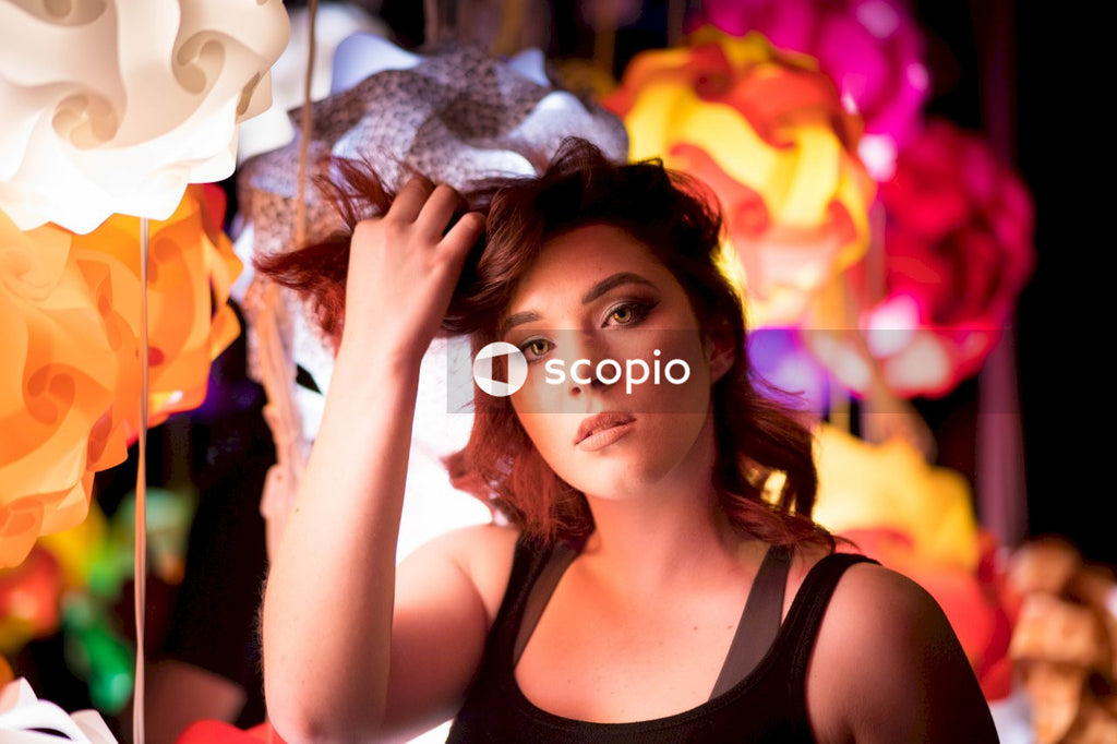 Portrait of young woman touching her hair standing outdoor at night