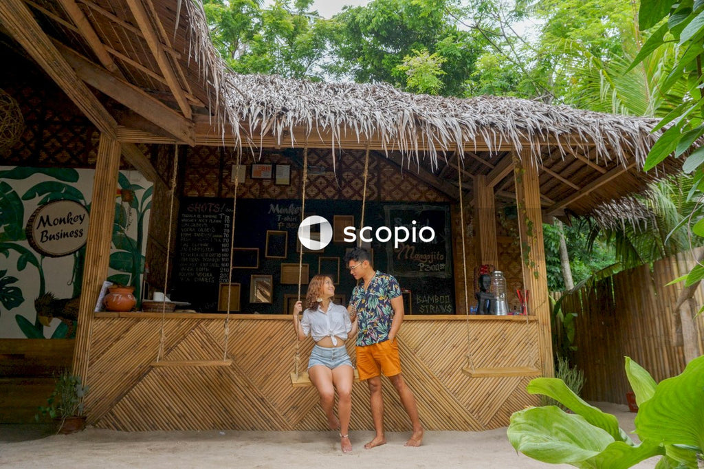 Woman sitting on a swing beside a man near wooden bar
