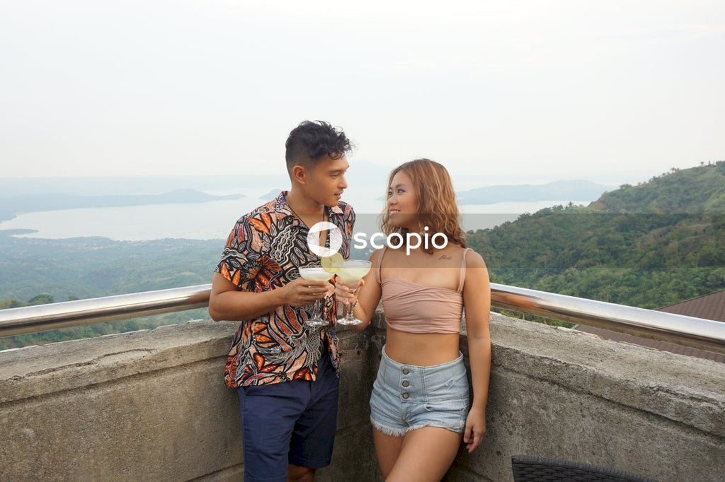 Man and woman drinking margaritas near natural landscape