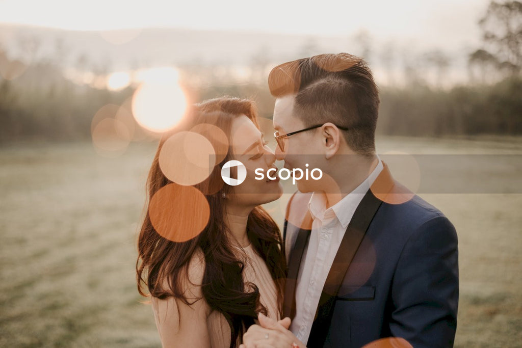 Man in black suit kissing woman in white dress