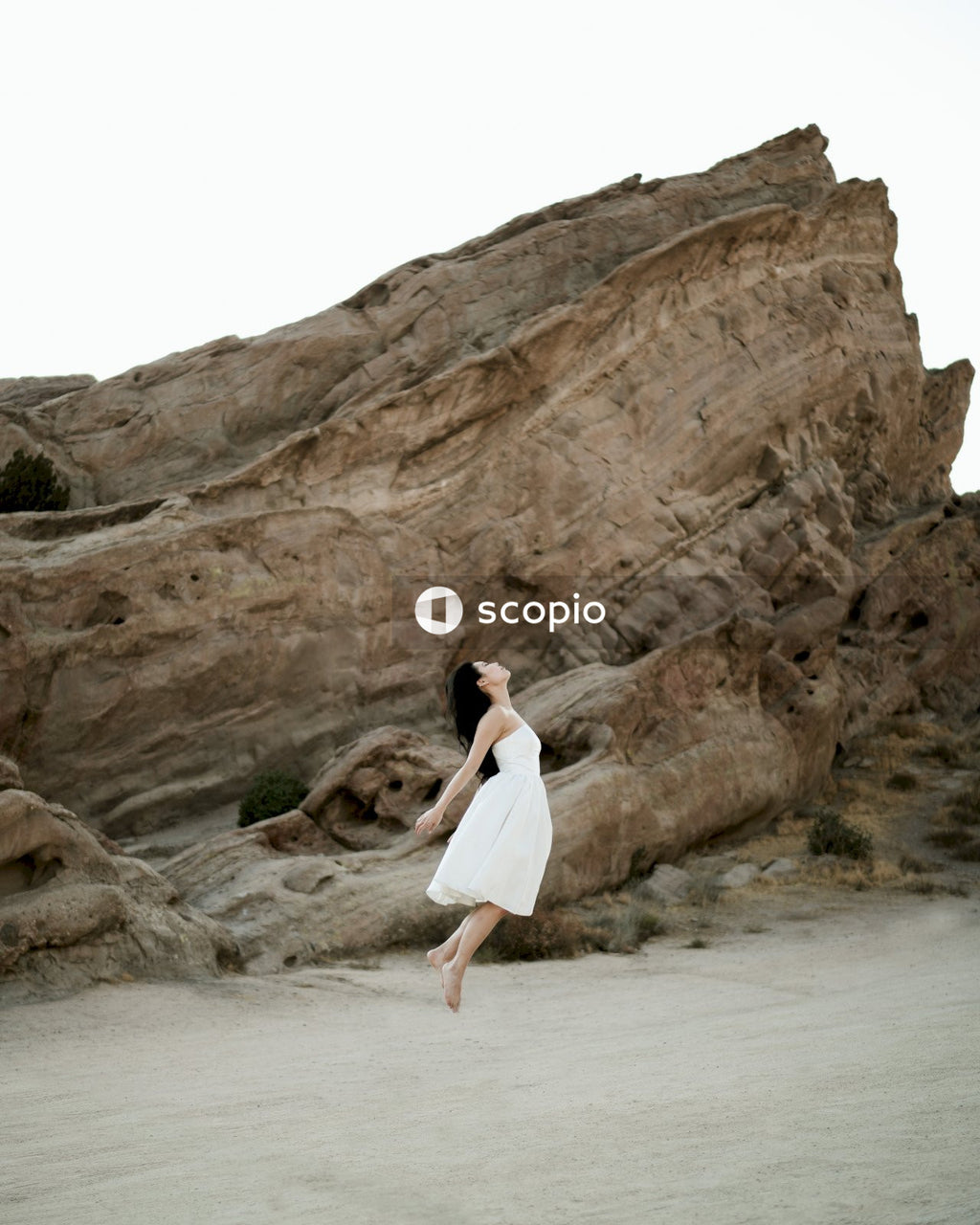 Woman in short light dress standing on sandy shore