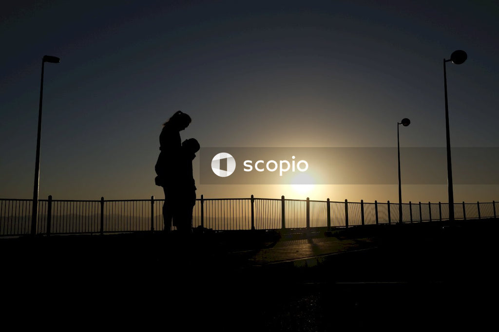 Silhouette of person standing on road during sunset