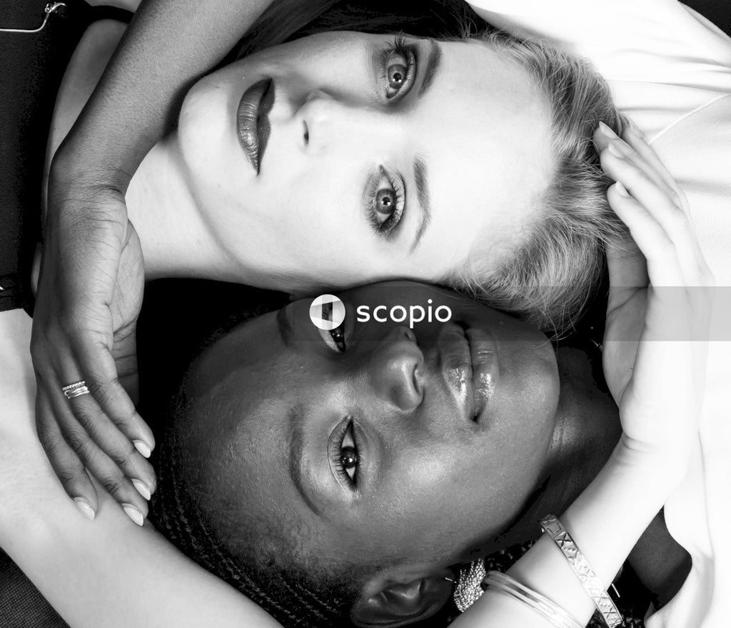Grayscale photo of two women laying beside each other