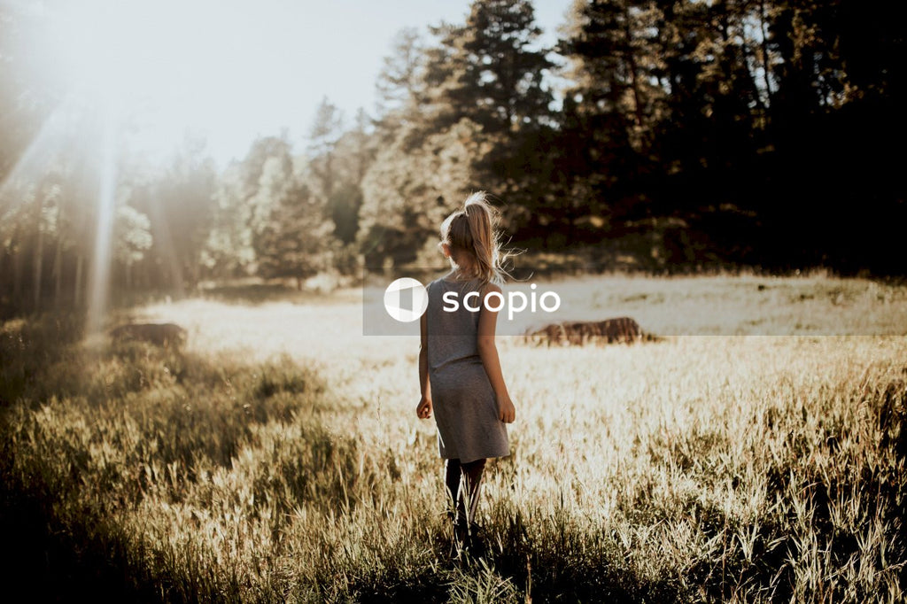 Woman in beige dress standing on grass field