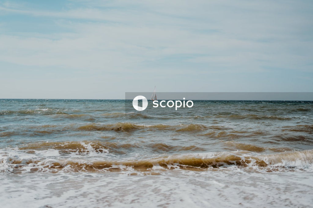 Sailboat on sea under white sky